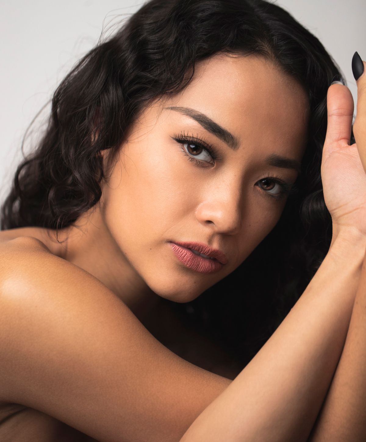 Close-up portrait of a woman with curly hair.