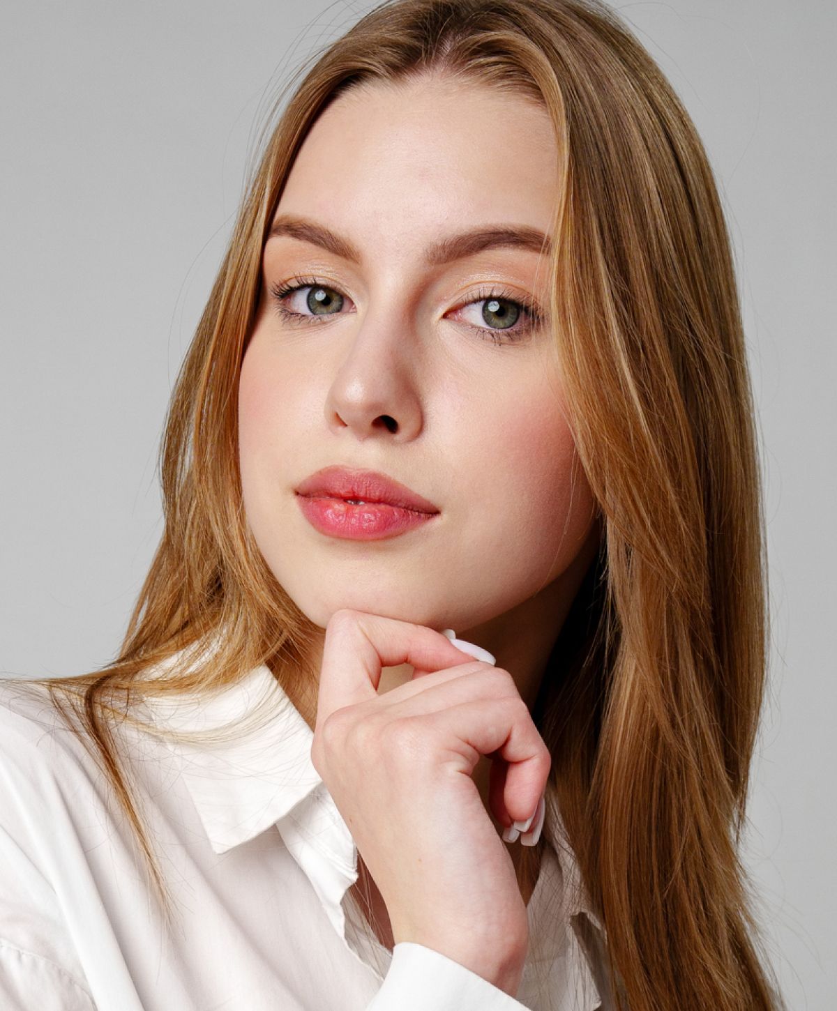 Model with long hair resting chin on hand