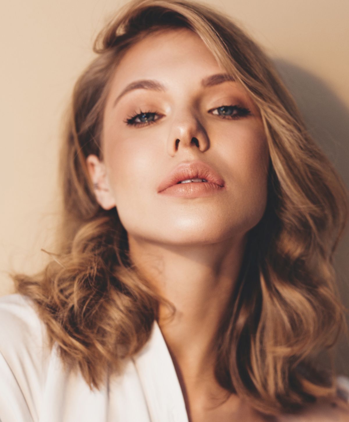 Female model with long brown hair, neutral expression.