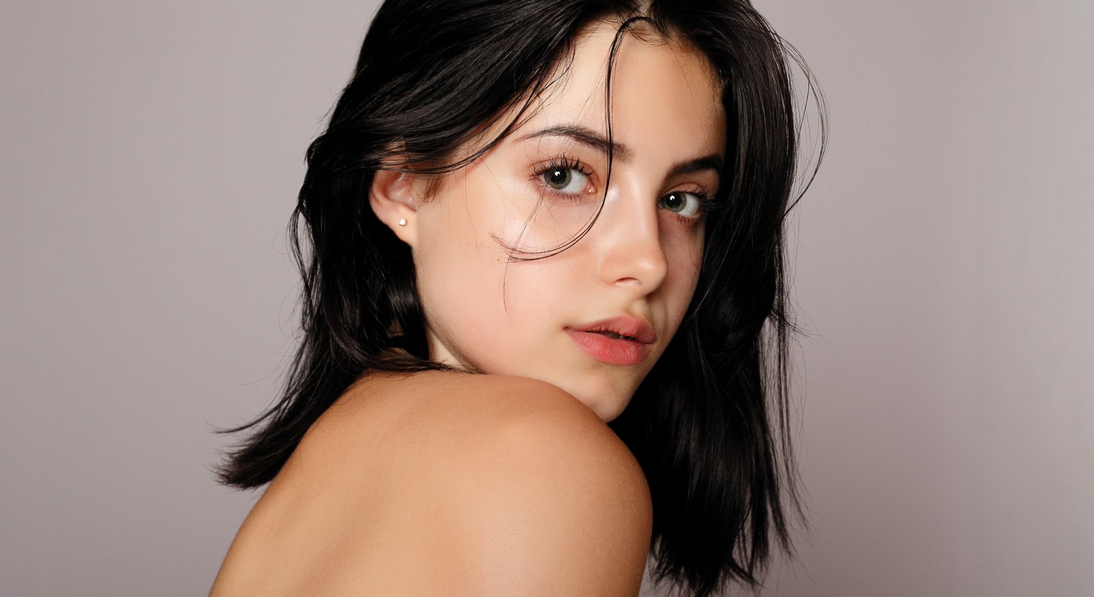 Female model with long hair looking over shoulder.