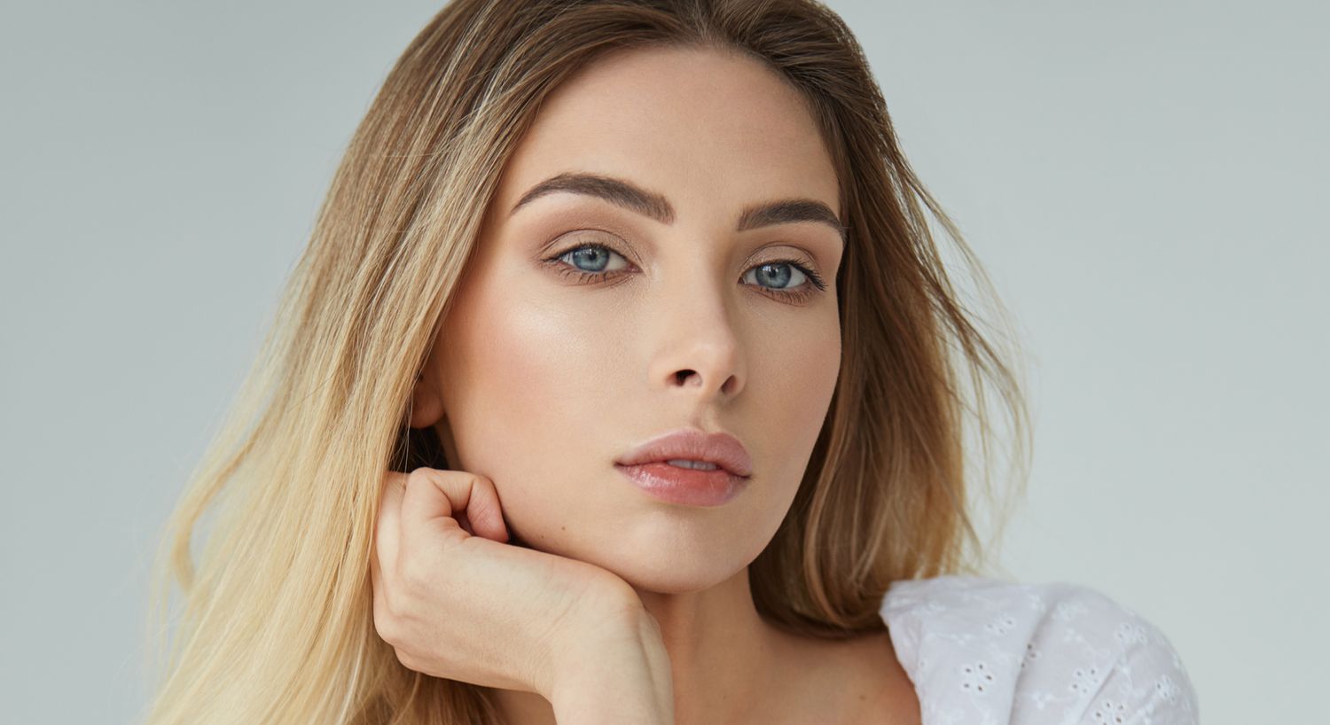 Model with long hair posing thoughtfully indoors.